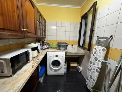 a kitchen counter with a microwave and a washing machine at Machico View in Machico
