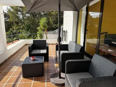 a patio with chairs and an umbrella on a building at Machico View in Machico