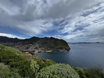 a patio with two chairs and an umbrella at Machico View in Machico