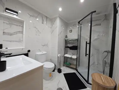 a bathroom with a shower and a toilet and a sink at Cozy Airport Apartment in Machico