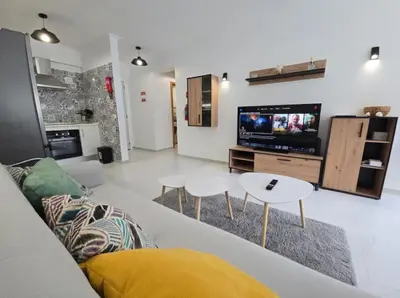 a living room with a couch and a tv at Cozy Airport Apartment in Machico