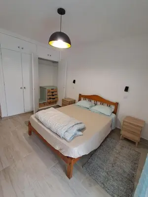 a bedroom with a large bed and a pendant light at Cozy Airport Apartment in Machico