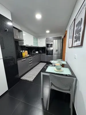 a kitchen with a table and chairs in it at Ocean View Oasis Funchal with Parking in Funchal