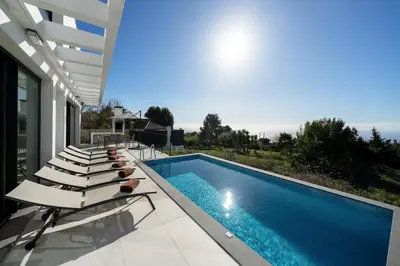 a swimming pool with lounge chairs next to a house at OurMadeira - Casa Laranja in Prazeres