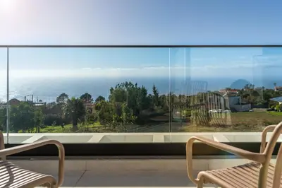 a room with a large window with two chairs at OurMadeira - Casa Laranja in Prazeres