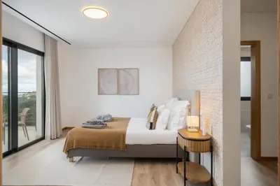 a bedroom with a bed and a brick wall at OurMadeira - Casa Laranja in Prazeres
