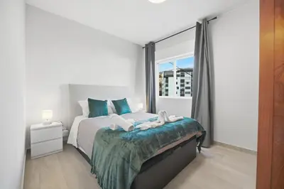 a bedroom with a bed and a large window at Little Paradise - Funchal in Funchal