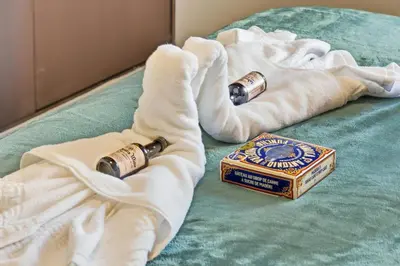 a bed with two towels and a box of cigarettes at Little Paradise - Funchal in Funchal