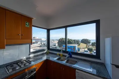 a kitchen with a sink and two large windows at Apartamentos Amarelo in Caniçal
