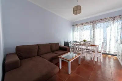 a living room with a brown couch and a table at Apartamentos Amarelo in Caniçal