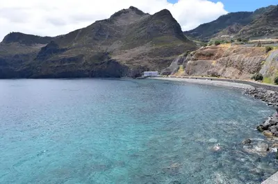 a large body of water with a mountain in the background at Apartamentos Amarelo in Caniçal