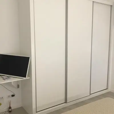 a room with white sliding closet doors at White Studio in Câmara de Lobos