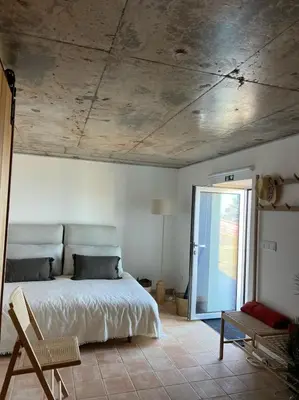 a bedroom with a bed and a door to a patio at Casa das Vacas - Retreat House in Ponta do Pargo
