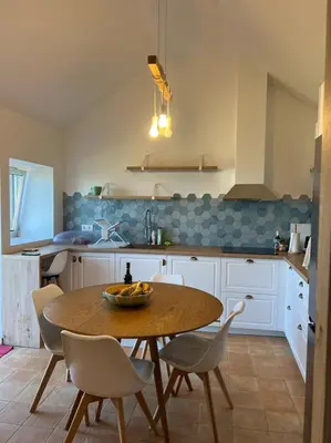 a kitchen with a wooden table and chairs and a sink at Casa das Vacas - Retreat House in Ponta do Pargo