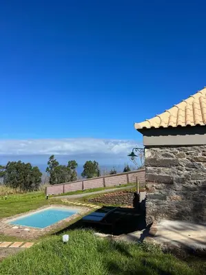 a backyard with a swimming pool and a stone building at Casa das Vacas - Retreat House in Ponta do Pargo
