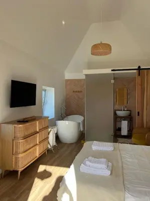 a bathroom with a bed and a tub and a television at Casa das Vacas - Retreat House in Ponta do Pargo