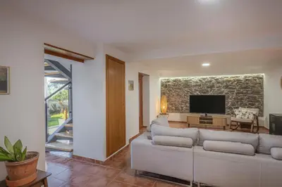 a grill and wicker chairs on a patio at New Quinta Aurora by Your Madeira Rentals in Estreito da Calheta