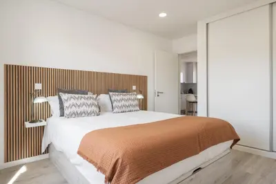 a bedroom with a large bed with a wooden headboard at Central Park Caniço Central Modern & Cozy in Santa Cruz