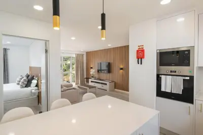 a kitchen and living room with a white table and chairs at Central Park Caniço Central Modern & Cozy in Santa Cruz