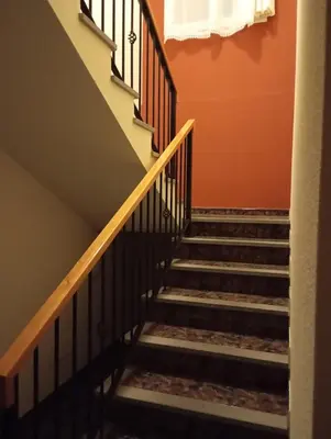 a staircase in a house with orange walls at Yellow Owl II Bedroom II in Campanário