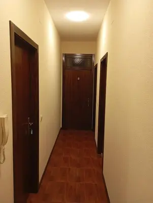 a hallway with two doors and a wooden floor at Yellow Owl II Bedroom II in Campanário