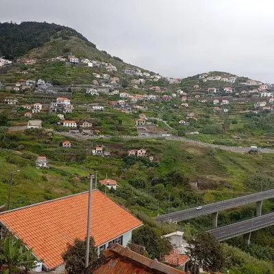 an orange roofed house on a hill with a highway at Yellow Owl II Bedroom II in Campanário