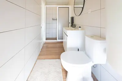 a white bathroom with a toilet and a sink at Romantic Seaview Wine House in Madeira in Ponta do Sol