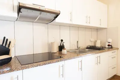 a kitchen with white cabinets and a sink at Romantic Seaview Wine House in Madeira in Ponta do Sol
