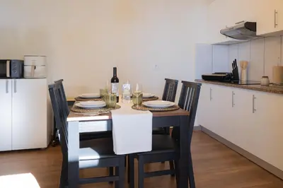 a kitchen with a table with chairs and a bottle of wine at Romantic Seaview Wine House in Madeira in Ponta do Sol