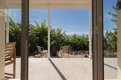 a sliding glass door with a view of the ocean at Romantic Seaview Wine House in Madeira in Ponta do Sol