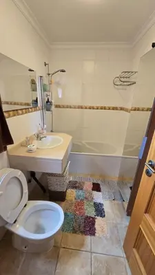 a bathroom with a toilet and a sink and a tub at Jardim do Sol in Nogueira
