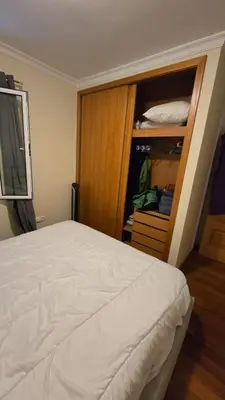 a bedroom with a white bed and a closet at Jardim do Sol in Nogueira