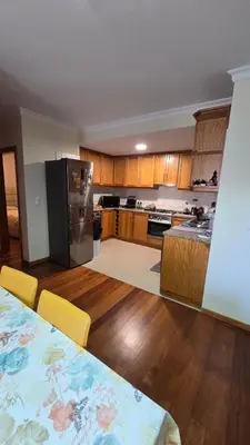 a large kitchen with a table and a refrigerator at Jardim do Sol in Nogueira