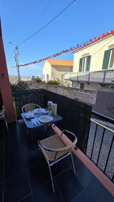a table and two chairs sitting on a balcony at Jardim do Sol in Nogueira