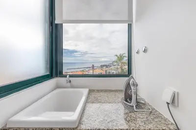 a bath tub in a bathroom with a window at Casa da Badé in Funchal