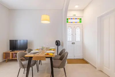 a dining room with a table and chairs and a tv at Casa da Badé in Funchal