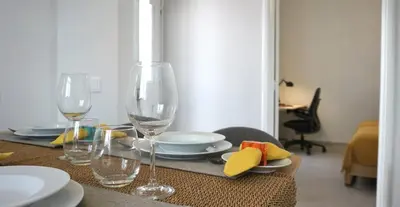 a table with two wine glasses and plates on it at Casa da Badé in Funchal