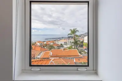 a window with a view of a city at Casa da Badé in Funchal