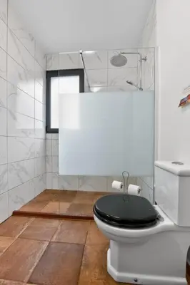 a bathroom with a toilet with a black lid at Sea view flat in Casa Teixeira Calheta Madeira in Estreito da Calheta