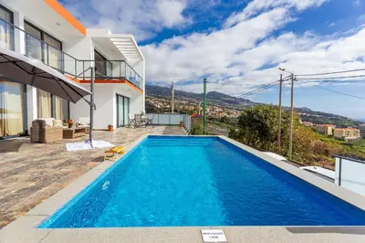 a villa with a swimming pool and a house at Sea view flat in Casa Teixeira Calheta Madeira in Estreito da Calheta
