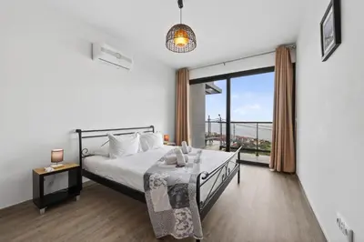 a bedroom with a bed and a large window at Sea view flat in Casa Teixeira Calheta Madeira in Estreito da Calheta
