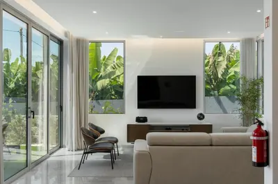 a living room with a couch and a flat screen tv at OurMadeira - BeachFront in Madalena do Mar