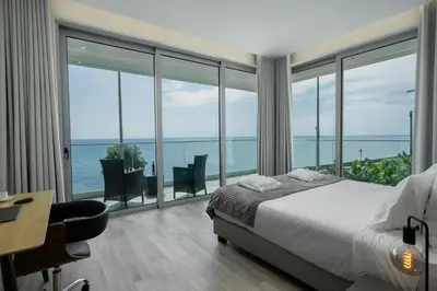 a bedroom with a bed and a view of the ocean at OurMadeira - BeachFront in Madalena do Mar