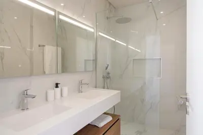 a white bathroom with a sink and a shower at OurMadeira - BeachFront in Madalena do Mar