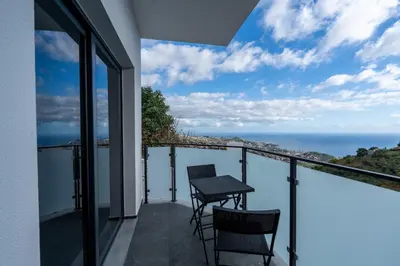 a balcony with a table and chairs and the ocean at Garachico Vista by LovelyStay in Estreito de Câmara de Lobos