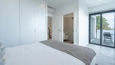 a white bedroom with a bed and a balcony at Garachico Vista by LovelyStay in Estreito de Câmara de Lobos