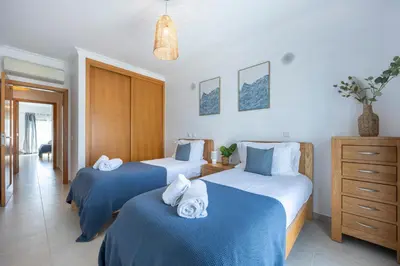 two beds in a hotel room with towels on them at Briso do Mós in Lagos