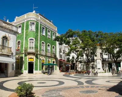 a green building with a spiral in the middle of a street at Briso do Mós in Lagos
