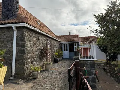 a stone house with a pathway leading to a door at Casa da Cruz in Ponta do Sol