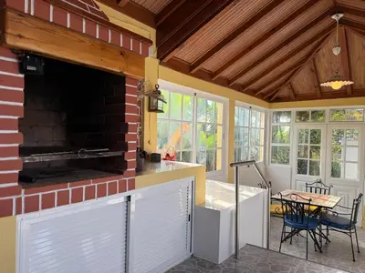 a kitchen with a brick fireplace and a table at Casa da Cruz in Ponta do Sol
